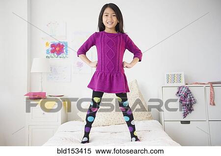 Smiling Vietnamese girl standing on bed View Large Photo Image Stock Photography - Smiling Vietnamese girl standing on bed. Fotosearch