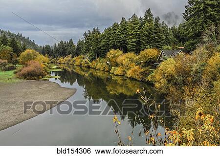 Stock Photograph - Still lake and house in remote forest. Fotosearch