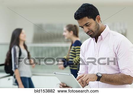 Stock Image - Student using digital tablet on campus. Fotosearch