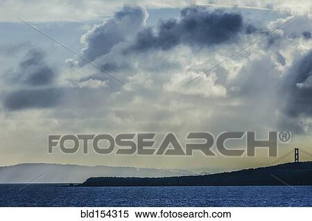 Stock Photography - Sunbeams shining through clouds over ocean. Fotosearch