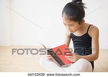 Stock Photo - Vietnamese ballet dancer reading book in studio. Fotosearch