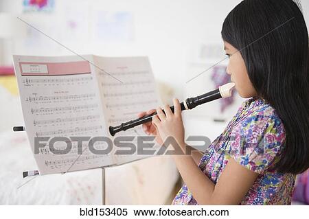 Vietnamese girl playing recorder from sheet music View Large Photo Image Stock Photography - Vietnamese girl playing recorder from sheet music. Fotosearch