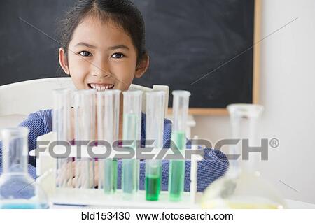 Stock Image - Vietnamese student doing science experiment in classroom. Fotosearch