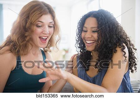 Woman admiring engagement ring of friend View Large Photo Image Stock Photography - Woman admiring engagement ring of friend. Fotosearch