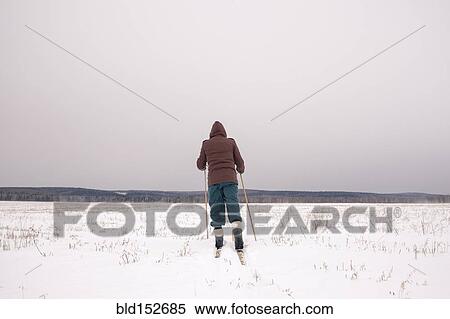 Woman cross-country skiing in snowy field View Large Photo Image Stock Photography - Woman cross-country skiing in snowy field. Fotosearch