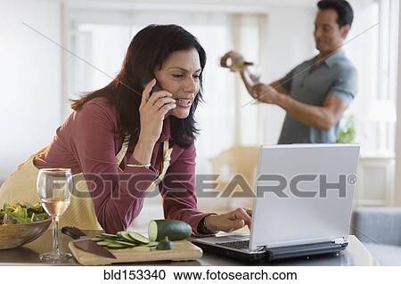 Woman working and cooking dinner with husband pouring wine View Large Photo Image Stock Image - Woman working and cooking dinner with husband pouring wine. Fotosearch