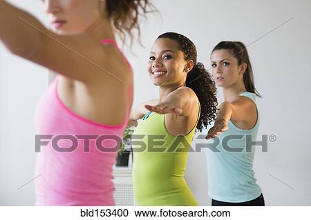 Stock Image - Women practicing yoga in class. Fotosearch