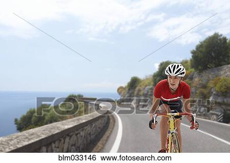 Caucasian cyclist biking on remote coastal road View Large Photo Image Stock Photograph - Caucasian cyclist biking on remote coastal road. Fotosearch