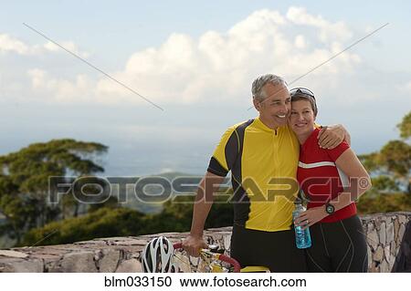 Caucasian cyclists hugging on remote road View Large Photo Image Stock Image - Caucasian cyclists hugging on remote road. Fotosearch