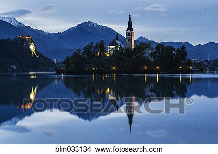 Church tower and trees reflecting in still lake View Large Photo Image Picture - Church tower and trees reflecting in still lake. Fotosearch
