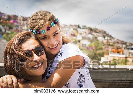 Close up of mother and daughter hugging on rooftop View Large Photo Image Stock Photograph - Close up of mother and daughter hugging on rooftop. Fotosearch