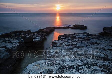 Stock Image - High angle view of rock formations over still ocean. Fotosearch