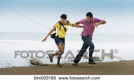 Hispanic couple playing near waves on beach View Large Photo Image Stock Photography - Hispanic couple playing near waves on beach. Fotosearch