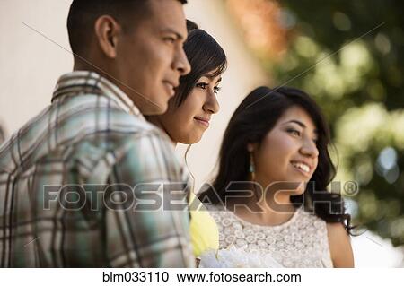 Stock Image - Hispanic family celebrating quinceanera outdoors. Fotosearch