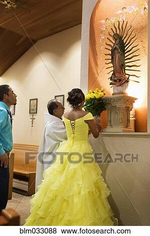 Stock Photo - Hispanic girl celebrating quinceanera in Catholic church. Fotosearch