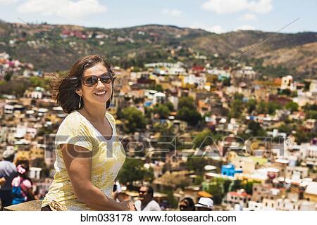 Stock Photo - Hispanic woman standing on scenic rooftop. Fotosearch