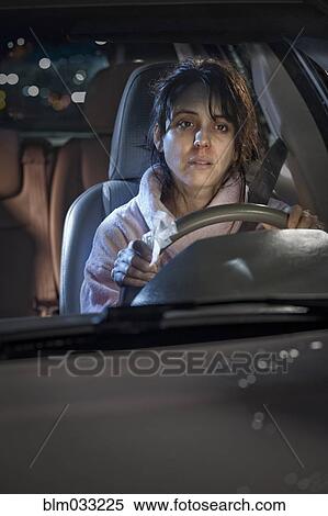 Stock Photography - Sick woman driving car at night. Fotosearch