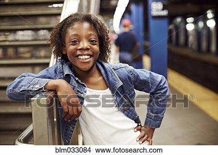 Picture - Smiling girl leaning on subway staircase. Fotosearch