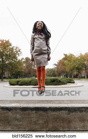 African American girl jumping on suburban street View Large Photo Image Stock Photography - African American girl jumping on suburban street. Fotosearch