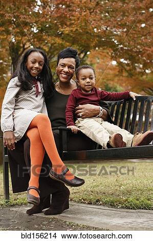 African American mother and children sitting on park bench View Large Photo Image Picture - African American mother and children sitting on park bench. Fotosearch