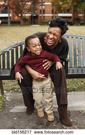 African American mother and son playing on park bench View Large Photo Image Stock Photo - African American mother and son playing on park bench. Fotosearch