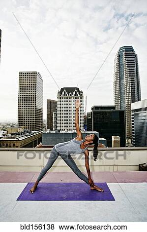 African American woman practicing yoga on urban rooftop View Large Photo Image Stock Photo - African American woman practicing yoga on urban rooftop. Fotosearch