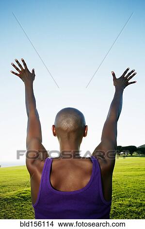 Picture - African American woman with arms outstretched in park. Fotosearch