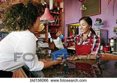 Barista serving customer with digital tablet register in coffee shop View Large Photo Image Stock Photograph - Barista serving customer with digital tablet register in coffee shop. Fotosearch