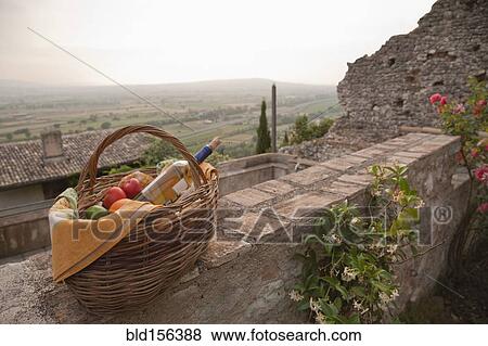 Basket of fresh fruit and wine on stone wall View Large Photo Image Stock Photo - Basket of fresh fruit and wine on stone wall. Fotosearch