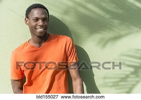 Black man standing under palm tree shadow on wall View Large Photo Image Stock Photo - Black man standing under palm tree shadow on wall. Fotosearch