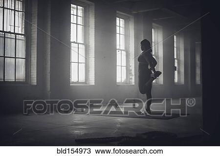 Black woman stretching in dark gym View Large Photo Image Stock Image - Black woman stretching in dark gym. Fotosearch