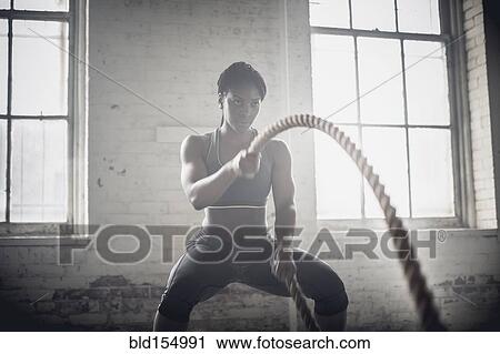 Black woman tossing ropes in dark gym View Large Photo Image Stock Image - Black woman tossing ropes in dark gym. Fotosearch