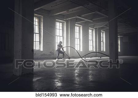 Black woman tossing ropes in dark gym View Large Photo Image Stock Image - Black woman tossing ropes in dark gym. Fotosearch