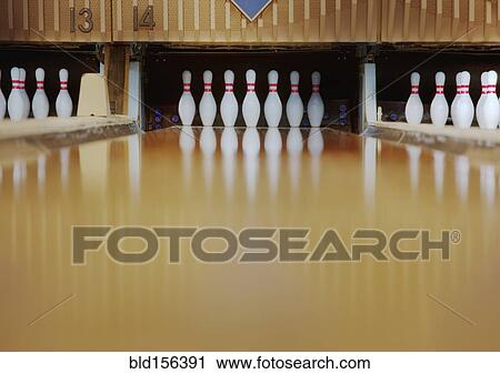 Stock Image - Bowling pins reflecting in bowling alley lane. Fotosearch