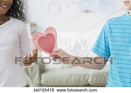 Stock Photograph - Boy passing Valentine to friend. Fotosearch