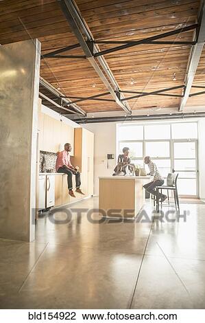 Stock Image - Business people relaxing in office kitchen. Fotosearch