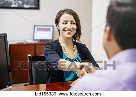 Stock Photo - Business people shaking hands in office. Fotosearch