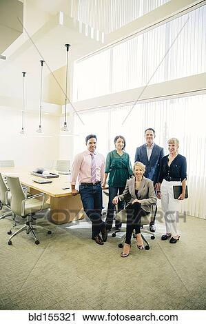 Stock Image - Business people smiling in office meeting. Fotosearch