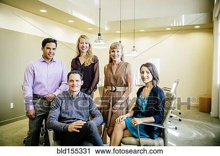 Stock Image - Business people smiling in office meeting. Fotosearch
