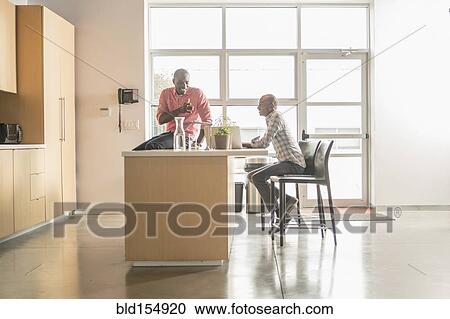 Stock Image - Business people talking in office kitchen. Fotosearch