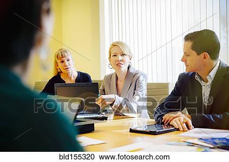 Stock Image - Business people talking in office meeting. Fotosearch