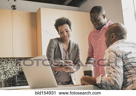 Business people using digital tablet in office kitchen View Large Photo Image Stock Image - Business people using digital tablet in office kitchen. Fotosearch