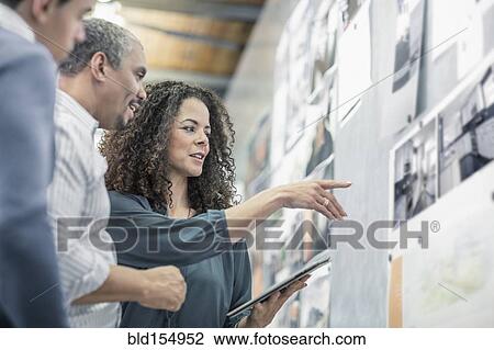 Business people using digital tablet in office View Large Photo Image Stock Image - Business people using digital tablet in office. Fotosearch
