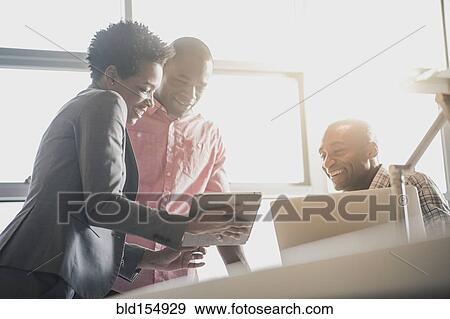 Stock Photo - Business people using digital tablet in office. Fotosearch