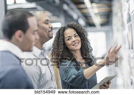 Stock Photo - Business people using digital tablet in office. Fotosearch