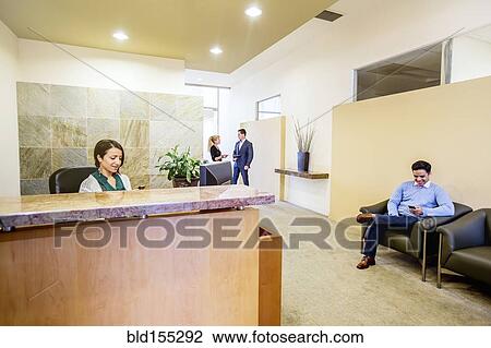 Stock Image - Business people working in office lobby. Fotosearch