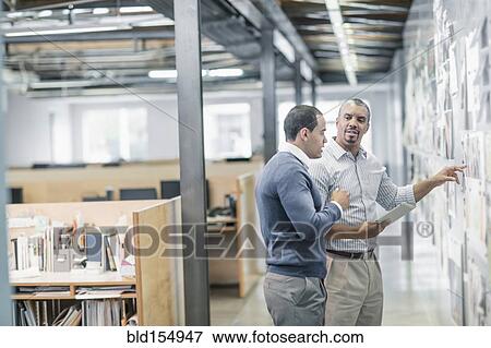 Stock Photo - Businessmen using digital tablet in office. Fotosearch