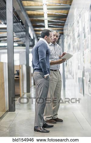 Businessmen using digital tablet in office View Large Photo Image Stock Photograph - Businessmen using digital tablet in office. Fotosearch
