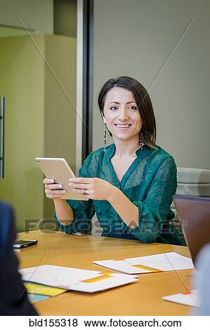 Stock Photo - Businesswoman using digital tablet in office meeting. Fotosearch