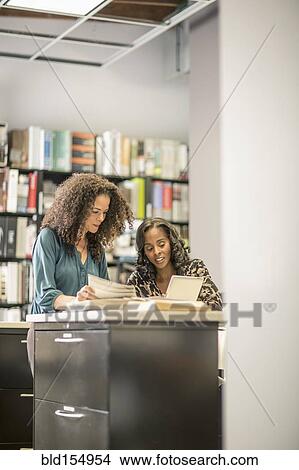 Businesswomen working together in office View Large Photo Image Picture - Businesswomen working together in office. Fotosearch